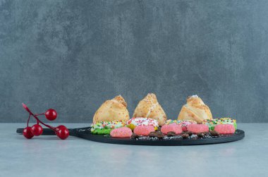 Mermer arka planda servis panosunda çeşitli tatlılar. Yüksek kalite fotoğraf