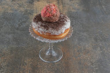 Kurabiye ve çörek tahta arka planda cam bir kaideye istiflenmiş. Yüksek kalite fotoğraf