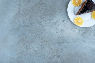Beyaz tabakta limon dilimleri olan bir dilim çikolatalı pasta. Yüksek kalite fotoğraf