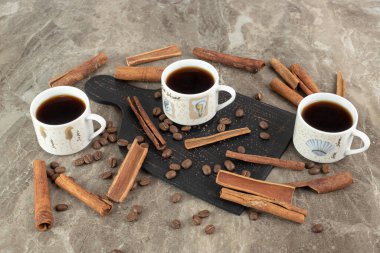 Espresso kahve, tarçın çubukları ve mermer yüzeyde kahve çekirdekleri. Yüksek kalite fotoğraf