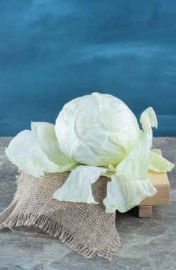 Ahşap tabakta yeşil lahana, trivet, mermer arka planda. Yüksek kalite fotoğraf