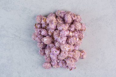 Mermer zemin üzerinde mor şekerle kaplı patlamış mısır yığını. Yüksek kalite fotoğraf