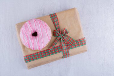 Kurdeleli hediye paketi ve beyaz arka planda jöleli çörek. Yüksek kalite fotoğraf