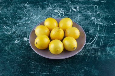 Mor tabakta ekşi sarı limon. Yüksek kalite fotoğraf