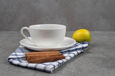 Bir fincan çay, tarçın çubukları ve mermer yüzeyde limon. Yüksek kalite fotoğraf