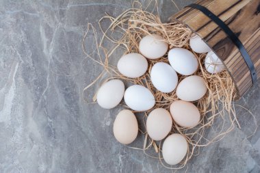 Mermer arka planda samanlı birkaç tane taze tavuk yumurtası. Yüksek kalite fotoğraf