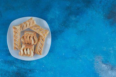 Mavi arka planda, tabağında reçel olan tatlı kurabiyeler. Yüksek kalite fotoğraf