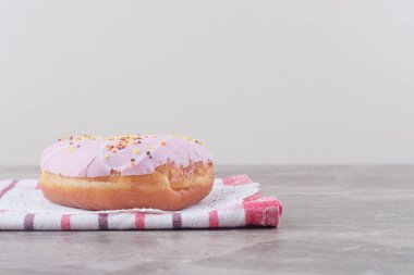 Mermer arka planda havlunun üzerindeki bir altlığa jöleli çörek. Yüksek kalite fotoğraf