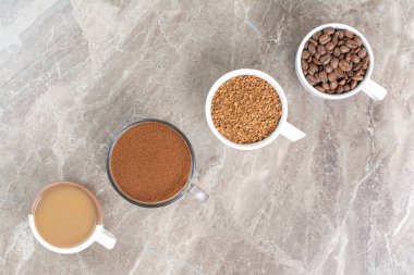 Kahve fincanları, kahve çekirdekleri ve mermer yüzeyde öğütülmüş kahve. Yüksek kalite fotoğraf