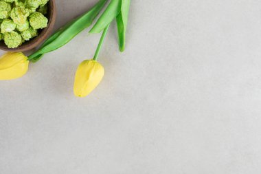 Bir kase şekerli patlamış mısır ve mermer zemin üzerinde sarı laleler. Yüksek kalite fotoğraf