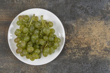 Beyaz tabakta yeşil üzüm kümesi. Yüksek kalite fotoğraf