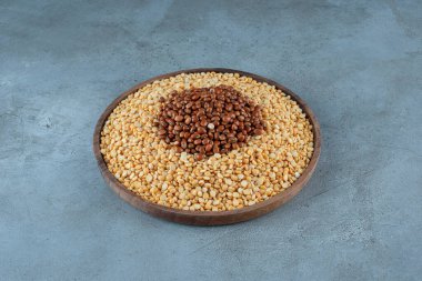 Mavi arka planda ahşap bir fincanda sarı bezelye çekirdeği. Yüksek kalite fotoğraf