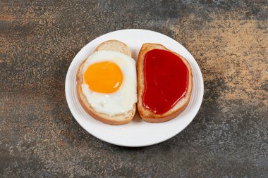 İki kızarmış ekmek, kızarmış yumurta ve beyaz tabakta reçel. Yüksek kalite fotoğraf