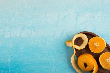 Dilimlenmiş turuncu ve mavi arka planda soyulmuş kabuk.