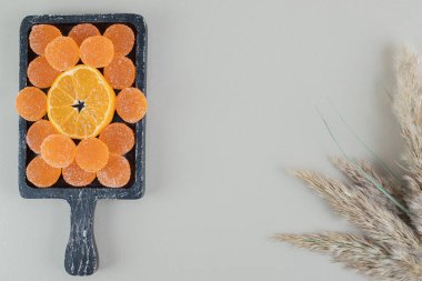 Şekerli şeker ve bir dilim portakalla dolu tahta bir tahta. Yüksek kalite fotoğraf