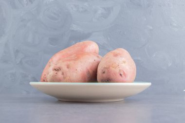 Tabakta, mermer zeminde bir patates görüntüsü. Yüksek kalite fotoğraf