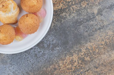 Ahşap arka planda sergilenen bir tepsi kapkek ve marmelat. Yüksek kalite fotoğraf