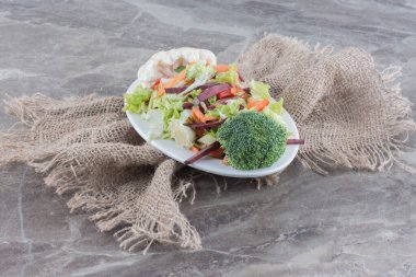 Lahana, karnabahar, brokoli, havuç ve mermer zemin üzerindeki pancar dilimlerinden oluşan salata tabağı. Yüksek kalite fotoğraf