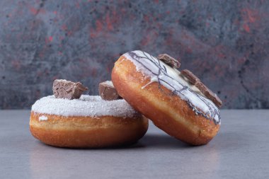 Mermer arka planda jöleli ve çikolata kaplı çörekler. Yüksek kalite fotoğraf