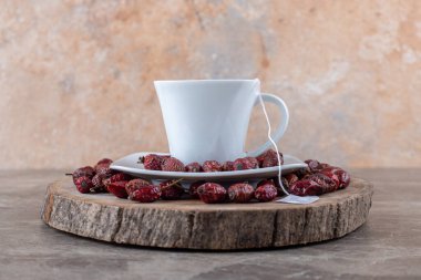 Rosehip meyvesi ve çay tahtada, mermer zeminde. Yüksek kalite fotoğraf