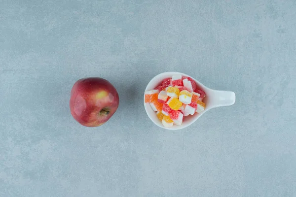 Una Manzana Pequeño Tazón Caramelos Sobre Fondo Mármol Foto Alta — Foto de Stock