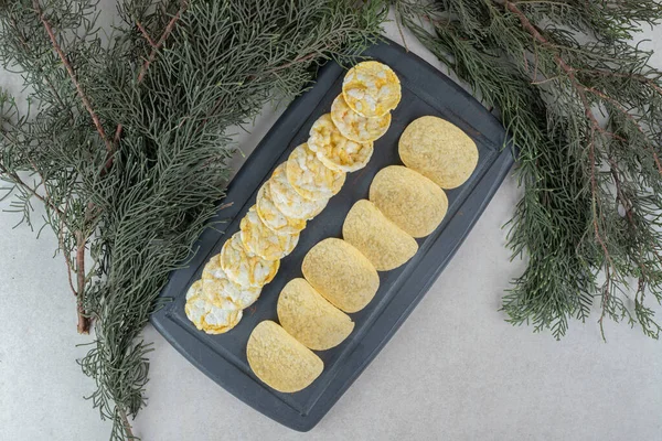 Two kinds of crispy chips on dark plate. High quality photo