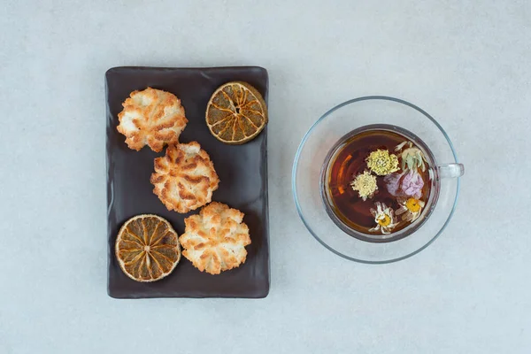 Una Taza Hierbas Con Galletas Naranjas Secas Plato Negro Foto — Foto de Stock