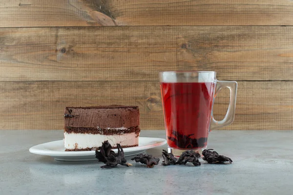 Slice of cake and glass of tea on marble table. High quality photo