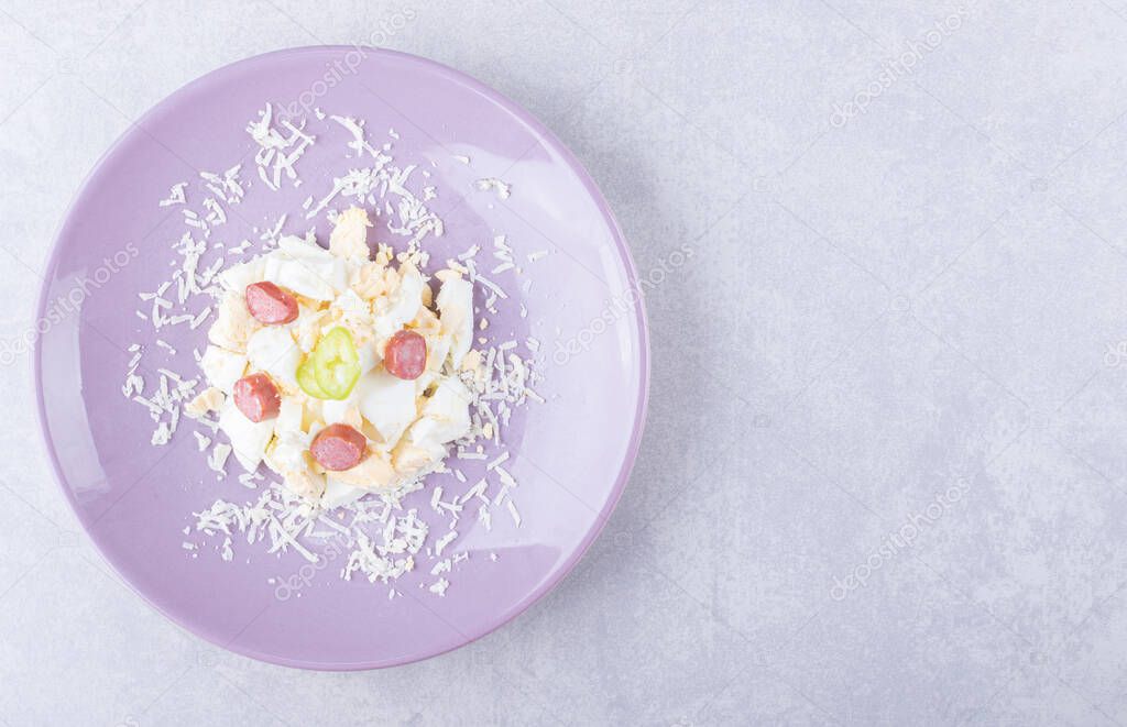 Grated cheese and egg with sausages on purple plate. High quality photo