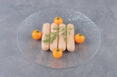 Bir tabak kaynamış sosis ve kiraz sarısı domatesler. Yüksek kalite fotoğraf