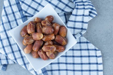Fars tarihleri kasede, çay havlusunda, mermer arka planda. Yüksek kalite fotoğraf