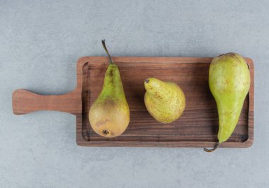 Mermer zemin üzerinde armut olan küçük bir ahşap tepsi. Yüksek kalite fotoğraf