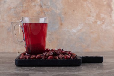 Çay ve güllük gülistanlık meyveler tahtada, mermer zeminde. Yüksek kalite fotoğraf