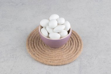 Mermer zemin üzerinde, trivet kupasında beyaz şekerler var. Yüksek kalite fotoğraf