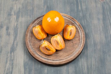 Tahta bir tabakta dilimlenmiş lezzetli hurma. Yüksek kalite fotoğraf