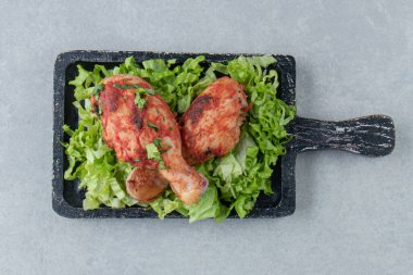 Kızarmış tavuk bacağı ve marul salatası ile ahşap bir tahta. Yüksek kalite fotoğraf