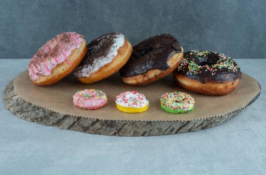 Mermer zemin üzerinde ahşap bir tahtanın üzerinde çeşitli çörekler. Yüksek kalite fotoğraf