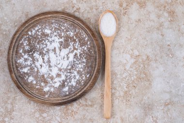 Kahverengi bir tabak un ve tahta bir kaşık şeker. Yüksek kalite fotoğraf