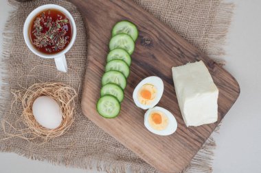 Dilimlenmiş salatalık ve haşlanmış yumurta ile bir fincan bitki çayı. Yüksek kalite fotoğraf