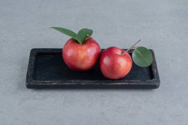 Mermer zemin üzerinde sulu elmalar olan küçük bir tepsi. Yüksek kalite fotoğraf