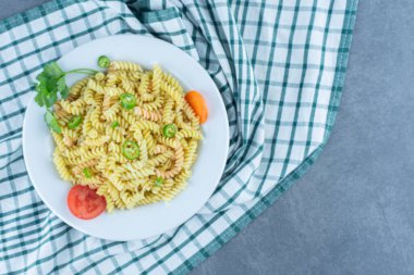 Beyaz tabakta sebzeli lezzetli fusilli makarna. Yüksek kalite fotoğraf