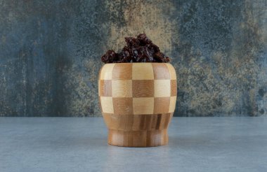 Mavi arka planda ahşap bir fincanda kurumuş ekşi kirazlar. Yüksek kalite fotoğraf