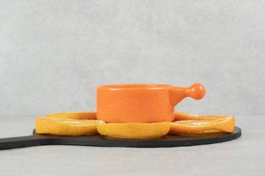 Koyu tahtada bir fincan kahve ve bir tabak portakal dilimi. Yüksek kalite fotoğraf