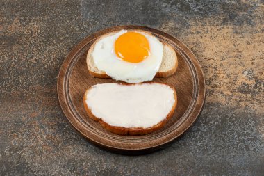 Beyaz ekmek dilimlerinin üzerinde tahta bir tabak taze yumurta. Yüksek kalite fotoğraf