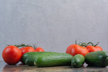 Mermer arka planda bir avuç domates ve salatalık. Yüksek kalite fotoğraf