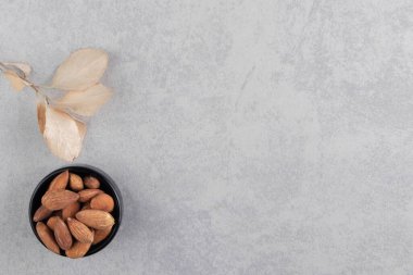 Yaprak ve bir kase badem, mermer arka planda. Yüksek kalite fotoğraf