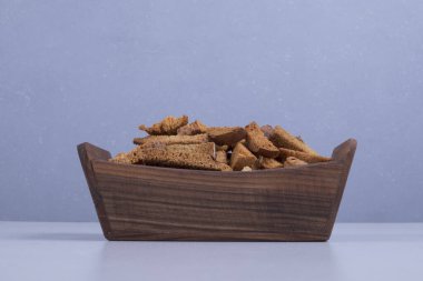 Ortadaki ahşap tepside mavi arka planda ekmek krakerleri. Yüksek kalite fotoğraf