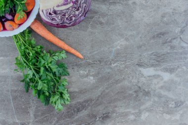 Maydanoz demeti, tek havuç ve yarım dilimlenmiş kırmızı lahana mermer arka planda salata kasesi. Yüksek kalite fotoğraf