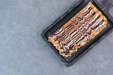 Gri arka planda koyu renkli bir pasta tahtası. Yüksek kalite fotoğraf