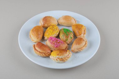 Küçük çörekleri mermer arka planda beyaz bir tabakta servis etmek. Yüksek kalite fotoğraf